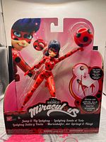 Front view of sealed Miraculous Ladybug figure showing artwork, figure, accessory and Bandai branding