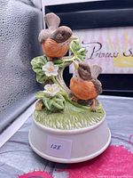 Front view of bisque porcelain music box with two robins on branch