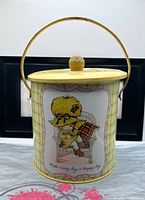 Front view showing Bonnie Bonnets graphic, lid, handle