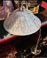 Pendant light with frosted glass shade, metal chain, ceiling canopy