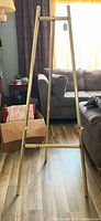 Full view of gold-tone metal easel standing on floor