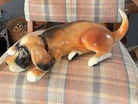 Full side view of ceramic dog door stop on chair