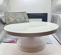 Side view showing cake stand on pedestal and bacon press backing