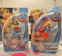 Front view of both blister-packaged figures: Wonder Woman and Supergirl