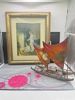 Front view showing framed print and metal sailboat sculpture together