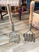 Both potato mashers standing upright showing full form