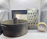 Overall lot showing tube pan, vintage flat grater, Joie mini grater