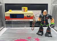 Front view of pocket camera and Gil Gripper figure