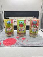 Front view of three sealed UglyDolls Surprise Disguise tubes displaying figures