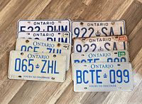All eight Ontario license plates displayed on wood floor