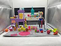 Overall view of entire lot including Harley Quinn figure, LPS salon, Shopkins spread on mat