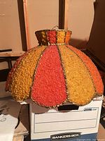 Full view of bell-shaped popcorn-texture shade on box