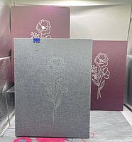 Front view of three binders showing cover colors and floral designs