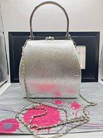 Front view showing silver finish, top handle, chain strap