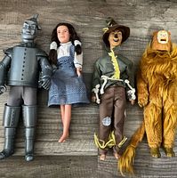 Group photo of all four Wizard of Oz figures laid out side by side