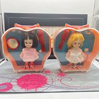 Two Cutie Pie doll sets in original carry cases