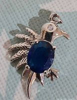 Front view of bird pendant showcasing blue crystal body and clear crystal eye