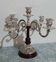 Full view of silver tone candelabra showing four arms and wood column
