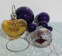 Group shot showing heart ornament on stand, mosaic globe, five purple spheres