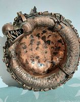 Top view of bronze/copper bowl showing coiled dragon rim and interior wear