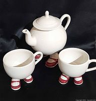 Full view of teapot and two cups showing Walking Ware design