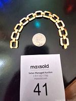 Bracelet curved beside quarter for scale
