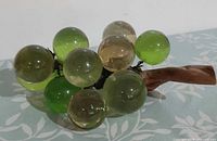 Oblique view showing entire lucite grape cluster on driftwood