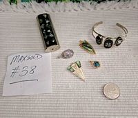 All five jewellery items laid out with quarter for scale