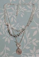 Full view showing three strands, pendant, and overall design