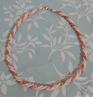 Full view of twisted pearl and coral necklace