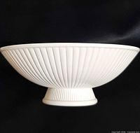 Side profile showing fluted exterior and pedestal base