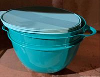 Two nested teal Tupperware XL Thatsa bowls with lids stacked on top