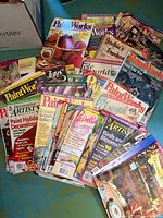 Stack of assorted folk art and tole painting magazines fanned out for visibility of different titles and covers