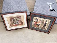 Both framed papyrus prints side by side on ground