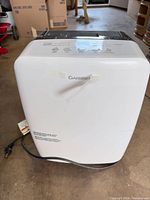 Front view of Garrison dehumidifier showing brand logo, water tank panel and power cord