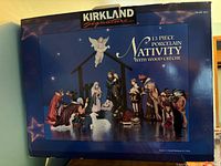 Front of original box showing Kirkland Signature 13-Piece Porcelain Nativity With Wood Creche