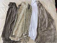 Five knit garments laid out on bed