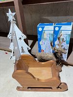 Entire lot showing wooden sleigh, metal tree, two boxed light-up trees, twig reindeer