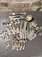 Full assortment of silver-plate flatware laid out on countertop