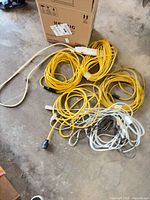Coiled yellow outdoor cords, indoor white/brown cords, power strip