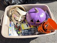 Tub containing purple pumpkin, orange pails, Guy Fawkes mask, packaged paper goods