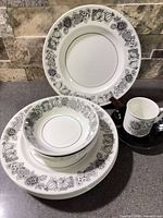 Group view of stacked plates, bowls, cup and saucer