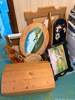 Group view of all wooden items leaning against wall including chest, plaques, tray, rack and plate