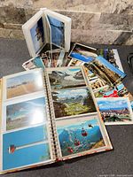 Open spiral album and flip album alongside stack of loose postcards