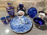 Group shot showing all cobalt blue, porcelain and silver-plated pieces