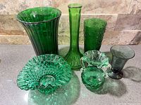Group shot of seven emerald green glass pieces on countertop