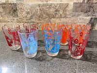 Eight printed juice glasses displayed on countertop