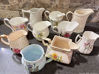 Group shot showing all ten vintage porcelain creamers with varied floral designs