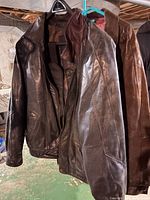 Black and brown leather jackets hanging side by side
