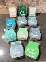 Nine assorted wax melt packs laid out on countertop